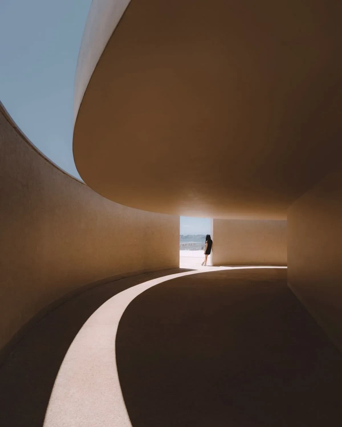 Curved architectural walkway in warm clay tones