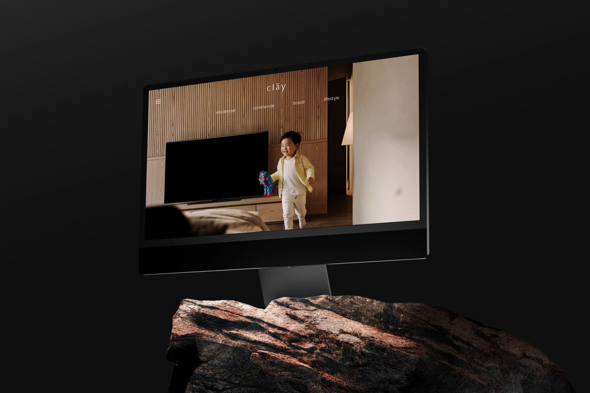 clāy website homepage displayed on an iMac standing on a rock