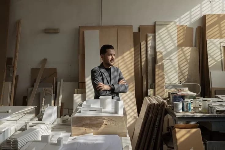 Designer working at a desk of prints