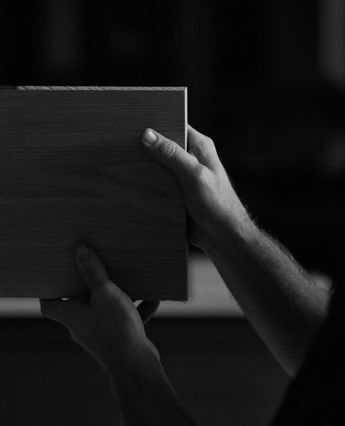 Hand reaching along a dark panel